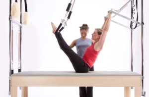 Woman doing Pilates on cadillac trapeze table